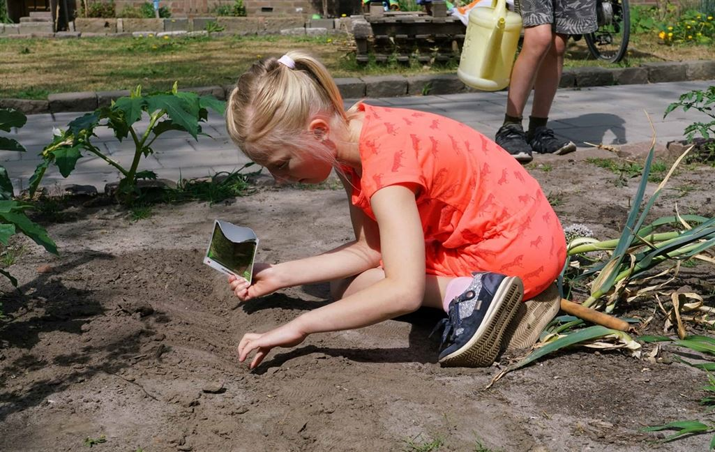  Kind plant zaadjes in een gemeenschappelijke tuin 